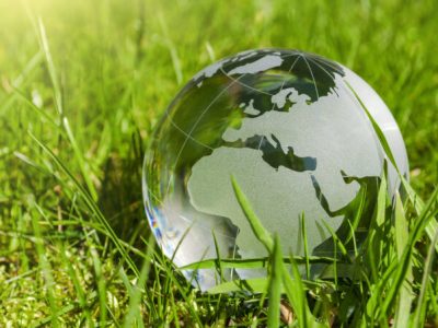 Weltkugel aus Glas, Erde mit Gras und Sonne, Naturschutz, Umweltschutz, Klimaschutz